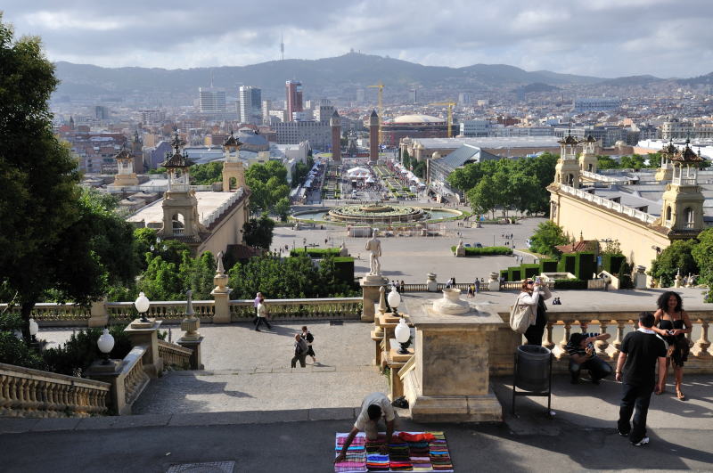中央に見える噴水は、モンジュイックの魔法の泉[Fuente magica de Montjuic]、その向こうの通りはレイナ・マリア・クリスティナ通り、その突き当たりにスペイン広場[Plaça Espanya]がある。